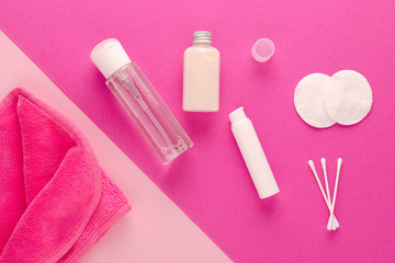 Obraz na płótnie Canvas make up remove products, micellar water, face cleaning cloth, cleansing milk and gel with cotton pads on pink background