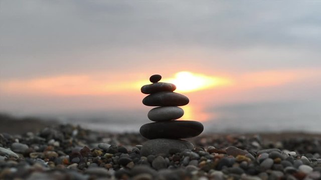 pyramid of stones by the sea. zen balanced stones on the dawn.