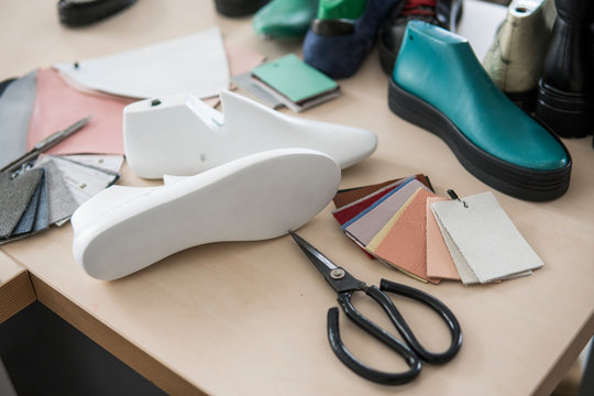 Shoemaker workplace with tools, shoes, leather and last.