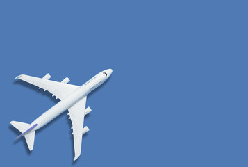 Fototapeta na wymiar Flat lay of miniature toy airplane on blue background minimal trip and travel creative concepts. copy space
