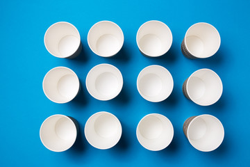 Paper cup for hot coffee or tea on a blue isolated background.
