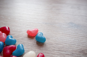 Obraz premium Valentines day card with tiny candy sweet hearts on wooden background. Flat lay, top view, copy space. 