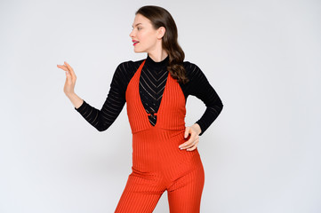 Concept adult girl on a white background. A photo of a pretty brunette girl in red trousers and a...
