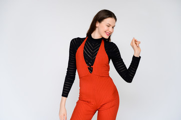 Concept adult girl on a white background. A photo of a pretty brunette girl in red trousers and a...