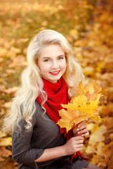 Naklejka na ściany i meble young russian blonde walks in the park with fallen maple leaves