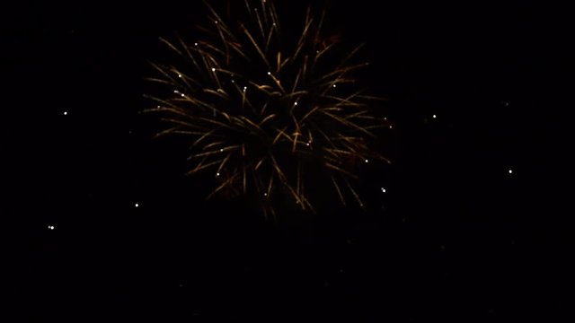 magical golden strobe fireworks blink and shimmer in calm night sky close view slow motion