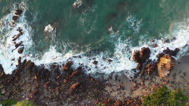 Waves crushing on rocks on the beach in Mexico. Static drone footage. Beach seen from bird perspective