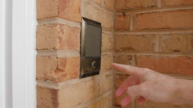 Ringing doorbell with index finger. Male hand pushing home intercom door bell button.