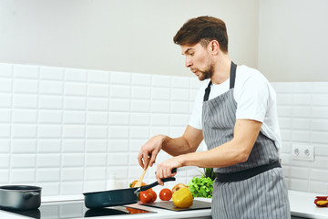 man cutting vegetables in kitchen