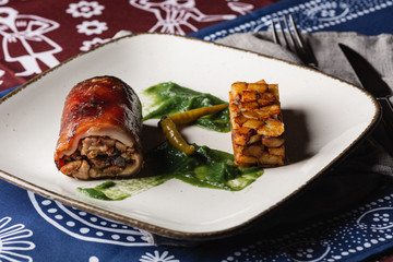 Roulette with meat with potato and spinach sauce, close up. served in restaurant