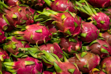 Dragon fruit with a lots of dragon fruit on a background. Dragon fruit or pitaya. Tropical and exotic fruits. Healthy and vitamin food concept.