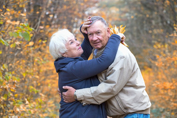 Fototapeta premium Senior man and woman hugging in an autumn park