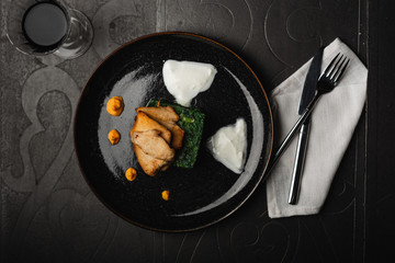 Grilled chicken breast with boiled spinach an hot cheese. top view served for restaurant