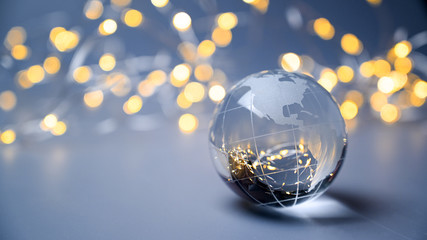 New year 2023. Earth ball globe on a blue silver background with golden lights. Christmas tree ball.