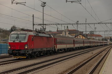 Fototapeta na wymiar Fast passenger train with red modern electric engine in Ilava station
