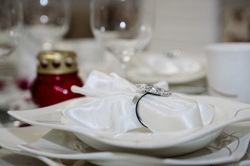 Fototapeta na wymiar Elegant decoration of table in a restaurant. Porcelain plates, silver cutlery and crystal glasses. Beautiful white napkin in a porcelain plate.