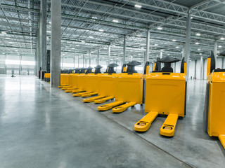 a lot of trucks standing in a row in a big, empty warehouse. the parade of trucks. new technology...