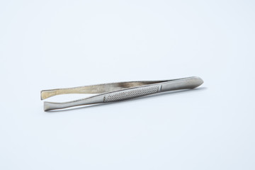  Small metal manicure tweezers on a white background