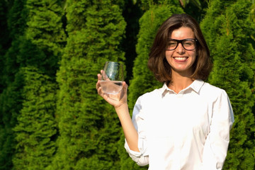 Young woman drinks water in garden