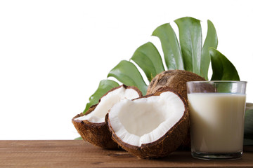 natural open coconut with glass of milk and exotic tropical leaf