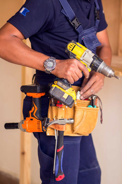 Handyman with headphones works with drill does repair.