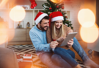 Love couple using tablet in home at Christmas time