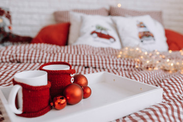 Cups on a tray in the bedroom on the bed .Christmas mood.