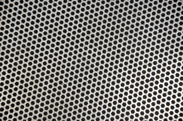 Abstract metallic perforated dark background with metal mesh effect texture.