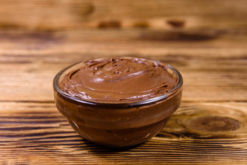 Glass bowl with chocolate spread on a wooden table