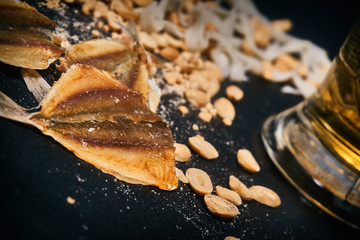 dried fish close-up on a background of peanuts and light beer.