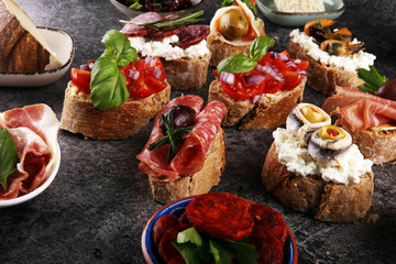 Appetizers table with italian antipasti snacks and wine in glasses. Brushetta or authentic traditional spanish tapas set, cheese variety