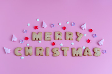 cookies letters Merry Christmas on pink background. creative Christmas concept.