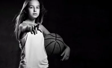 Fotobehang Beautiful caucasian teen woman in sportswear playing basketball . Sport concept isolated on black background. © FAB.1