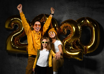 Happy and smiling. Group of beautiful young friends with inflatable numbers celebrating new 2020 year.