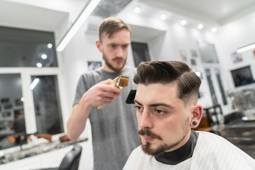 Customer smiling in barber shop with barber. Fun barber.