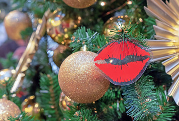 Christmas decoration in the form of red lips on a Christmas tree.