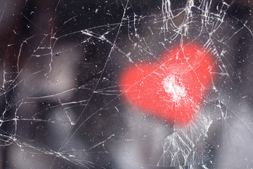 Mobile phone with cracks in the glass and a pattern in the shape of a heart on top