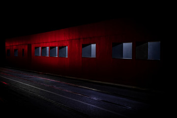 Fototapeta premium Light Spilling Out of Windows of a Red Wall onto a Road at Night, Dublin, Ireland