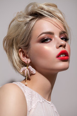 Portrait of young beautiful blond model with a professional make up, volume short bob haircut....