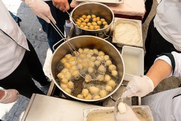 Greek traditional pastry desert loukoumades is deep fried crispy dounut balls served hot soaked with honey and sprinkled with cinnamon and sesame. Heraklion Crete Geece. Food concept.