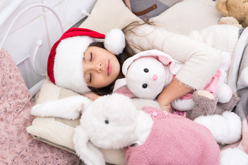 Magical morning. Christmas eve concept. Cozy room. Small child relaxing in bedroom. Kid lay in bed relaxing. Sweet home. Girl little kid relaxing on bed light interior with christmas decorations