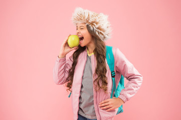 Schoolgirl happy daily life. Eating natural food. Lunch time. Winter semester. Teen with backpack. Healthy snack. Modern education. Stylish schoolgirl. Girl little smiling schoolgirl hold apple fruit