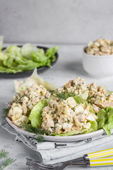 Calamari or squid salad with rice, egg, onion and dill served with green lettuce leaves. Delicious fresh salad. Keto diet.