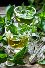 Two glass cups with fresh mint tea on wooden table