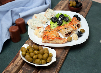 bun with meat, lavash roll and olives  on the table