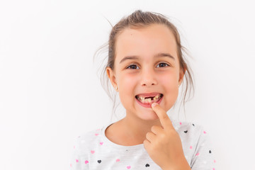 Little girl first tooth missing on a white background