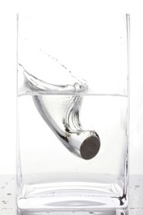 Coin splash in a glass of water