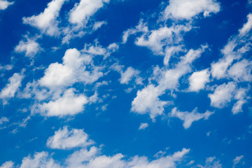 Puffy white scattered clouds across a deep blue sky