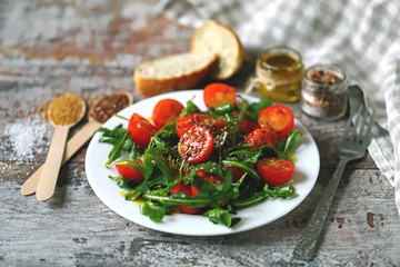 Healthy salad with arugula and cherry tomatoes with mustard sauce. Vegan food.