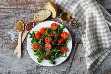 Healthy salad with arugula and cherry tomatoes with mustard sauce. Vegan food.